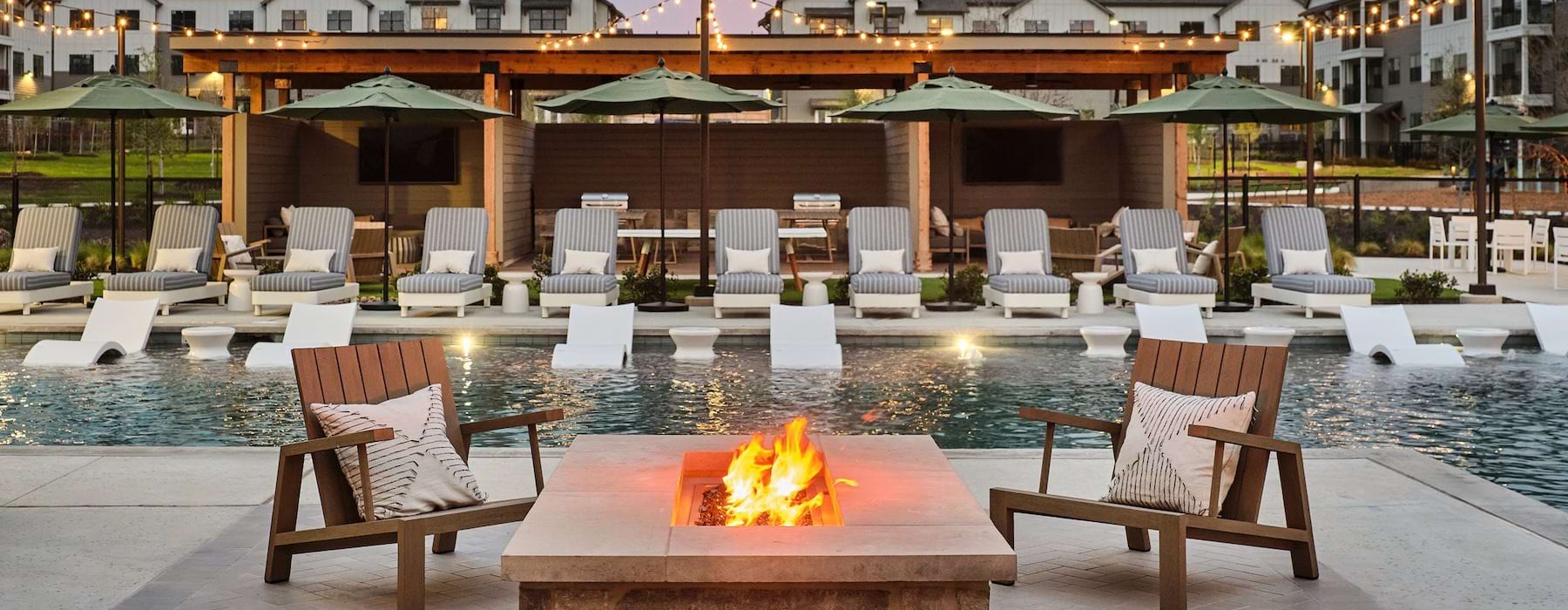 Resort-style pool with fire pit and seating at Citizen House Decker Austin, TX apartments
