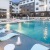 a pool with lounge chairs and a building in the background