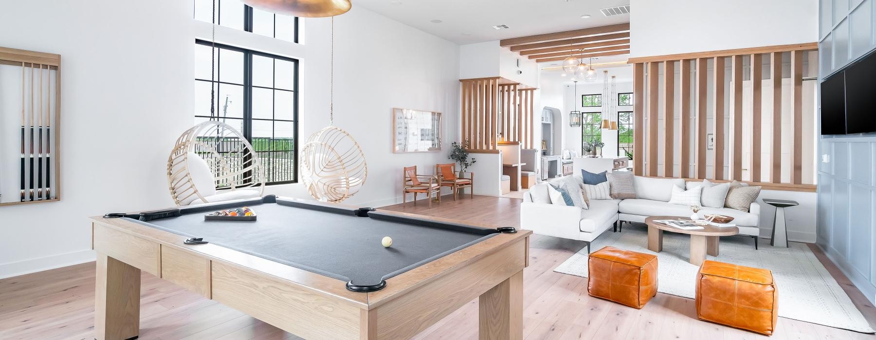 a room with a pool table and chairs